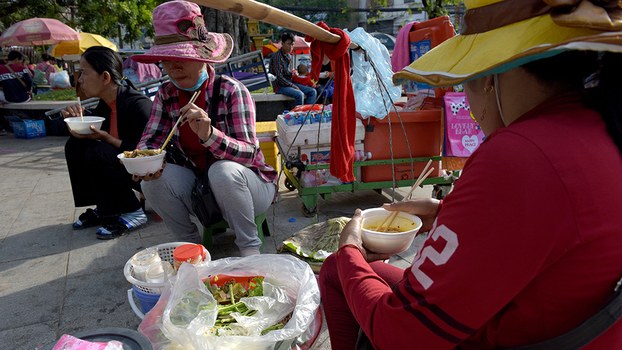  Customers eat noodles served by a street vendor in Phnom Penh, June 21, 2017. 