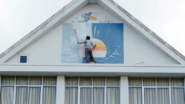  A supporter of the opposition Cambodia National Rescue Party (CNRP) paints over the party logo at party headquarters in Phnom Penh, Nov. 18, 2017. 